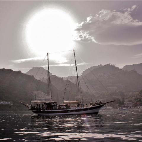 a small boat in a body of water with a mountain in the background