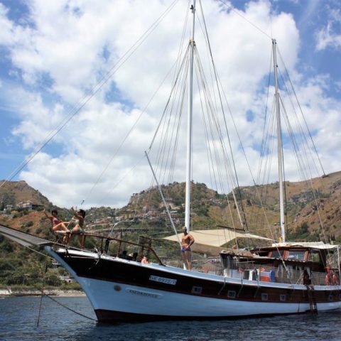 a small boat in a body of water with a mountain in the background