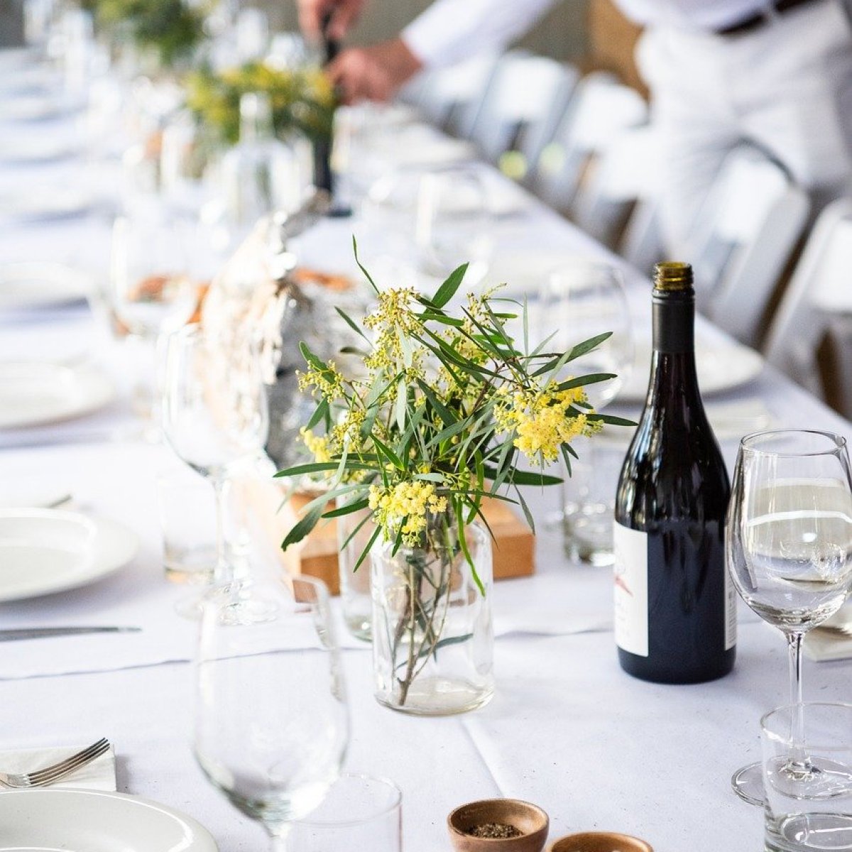 a person sitting at a table with wine glasses