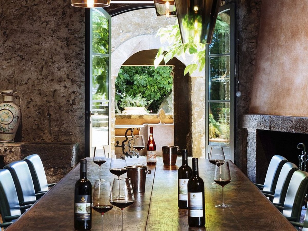 a room filled with furniture and a fire place and a glass of wine