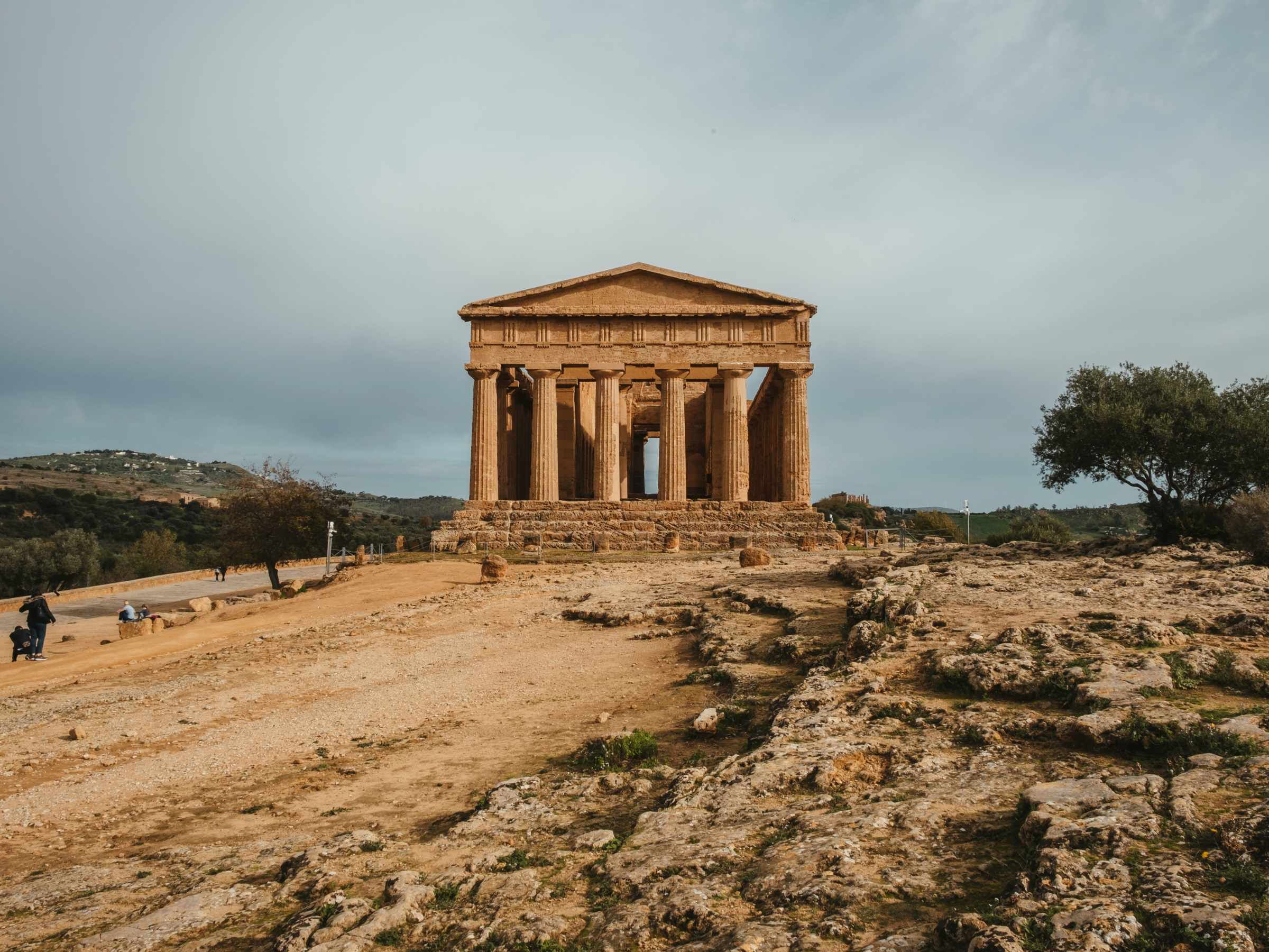 a group of people walking down a dirt road