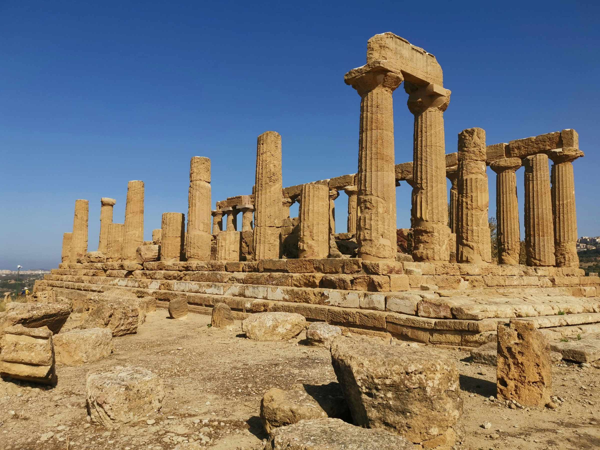 a large stone building with Agrigento in the background