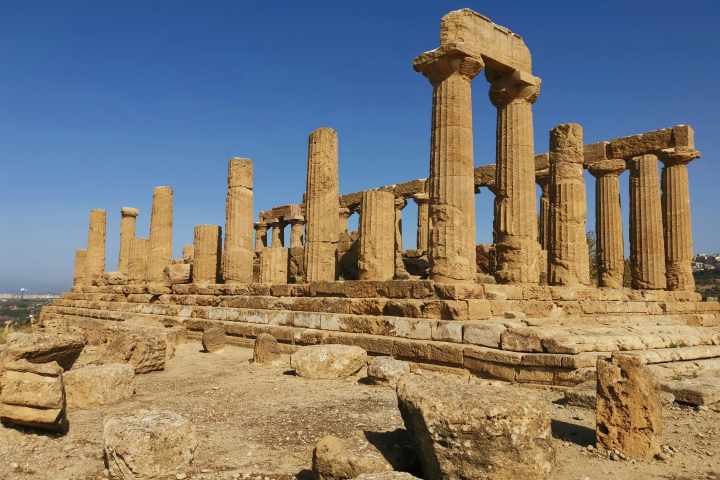 a large stone building with Agrigento in the background