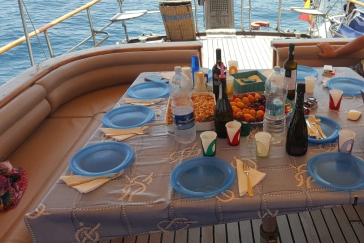 a group of people sitting at a table with food and water