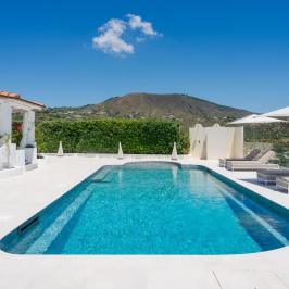Luxurious outdoor pool area with lounge chairs and umbrellas.