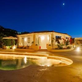 Night view of a luxurious villa with pool and ambient lighting.