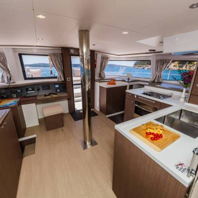 Spacious yacht interior with modern kitchen and sea view through windows.