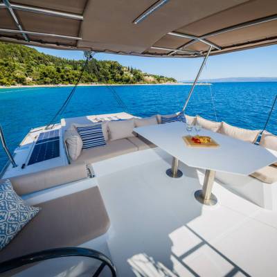 Luxury yacht deck with seating, table, and ocean view.