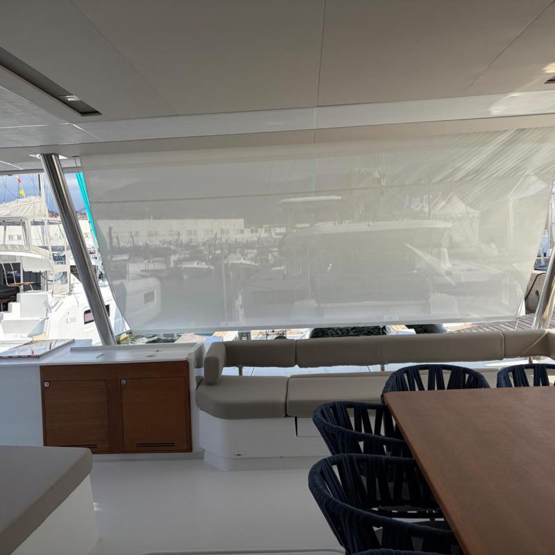 Luxury yacht deck with seating, table, and marina view.