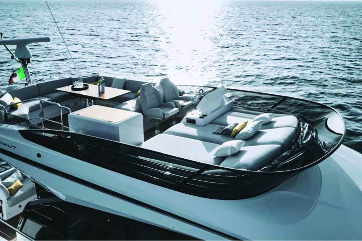 Luxury yacht deck with seating and table on a sunny day.