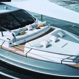 Luxury yacht deck with lounge chairs, cushions, and sunshade on calm water.