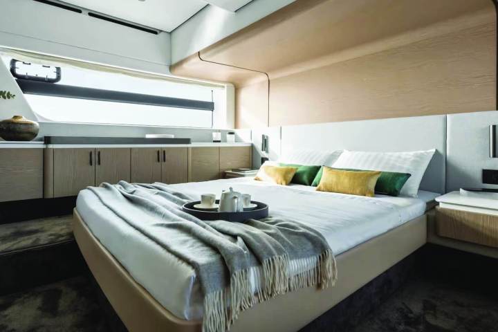 Modern yacht bedroom with a neatly made bed, window view, and decor accents.